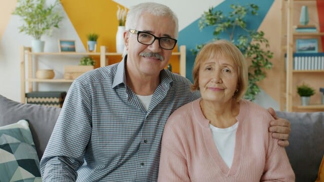 Seniorenpaar sitzt zusammen auf dem Sofa